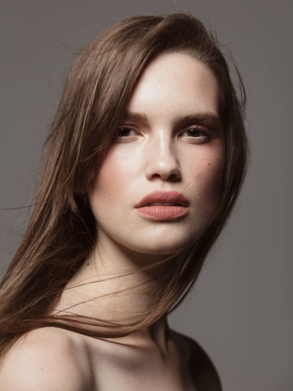 Retrato de mujer con maquillaje minimalista y collar de perlas, ejemplo de fotografía belleza minimalista, elegante y natural.