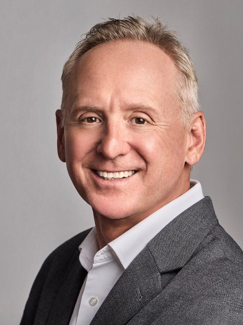 Professional headshot of executive with elegant corporate wardrobe on neutral background